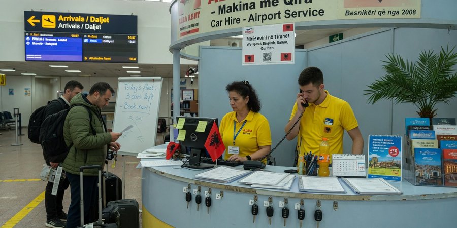 Wydanie kluczyków do auta z wypożyczalni w hali przylotów lotniska Tirana International
