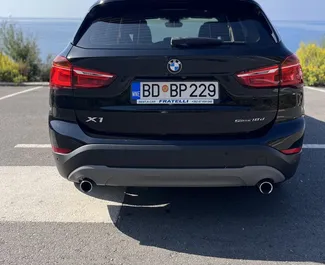 Wnętrze BMW X1 do wynajęcia w Czarnogórze. Doskonały samochód 5-osobowy. ✓ Skrzynia Automatyczna.