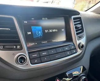 Wnętrze Hyundai Tucson do wynajęcia w Bułgarii. Doskonały samochód 5-osobowy. ✓ Skrzynia Automatyczna.