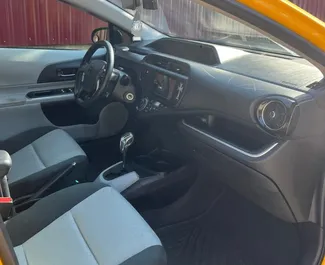 Wnętrze Toyota Prius C do wynajęcia w Gruzji. Doskonały samochód 5-osobowy. ✓ Skrzynia Automatyczna.