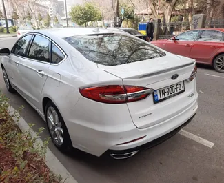 Wynajmij Ford Fusion Sedan 2019 w Gruzji. Paliwo: Hybryda. Moc: 188 KM ➤ Koszt od 140 GEL za dobę.