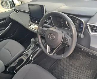 Wnętrze Toyota Corolla Sedan do wynajęcia na Cyprze. Doskonały samochód 5-osobowy. ✓ Skrzynia Automatyczna.